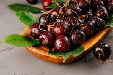  Tahta tabakta su damlaları olan taze kirazlar.