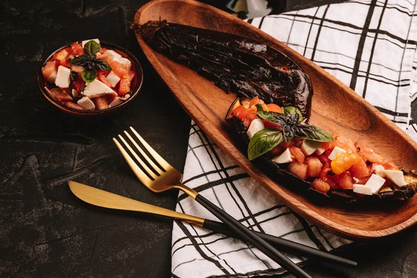Bakłażan pieczony z sałatką pomidorową, serem feta i bazylią na drewnianym talerzu — Zdjęcie stockowe