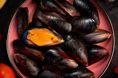 Kapalı tabakta siyah, çiğ midyeler.