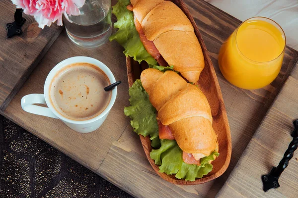 Reggeli az ágyban fából készült tálcán - szendvicsek, kávé és narancslé, közelkép — Stock Fotó