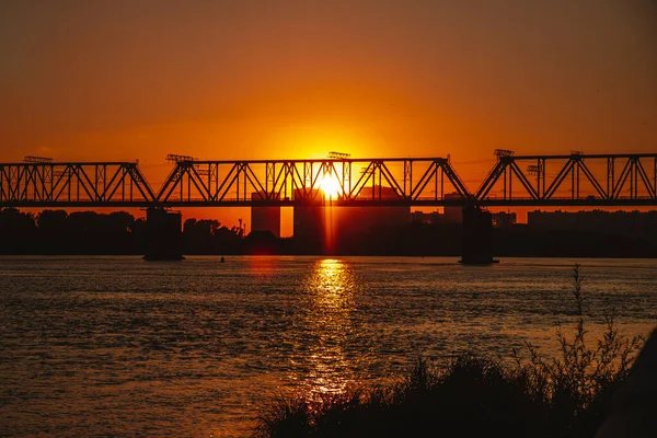 Railway bridge over the river during sunset