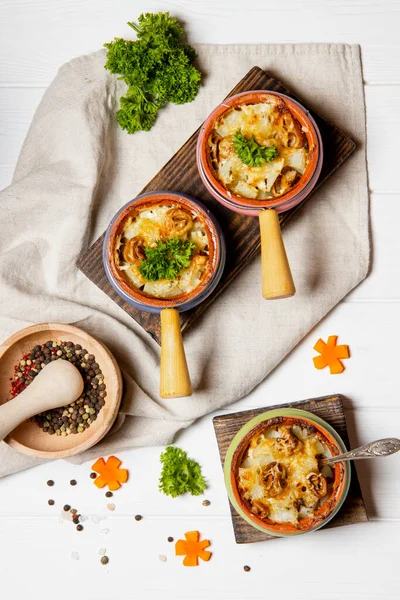 Porsiyonlu kaplarda peynir kabuğunun altında mantarlı fırında patates. Yüksek kalite fotoğraf