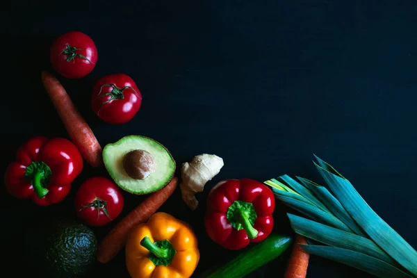 Different vegetables on a black background, top view, free space for the text. High quality photo