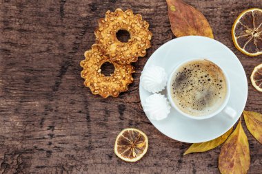  Bir fincan kahve, kurabiye ve sonbahar yaprakları ahşap arka planda, üst manzara, yazı için boş yer. Yüksek kalite fotoğraf