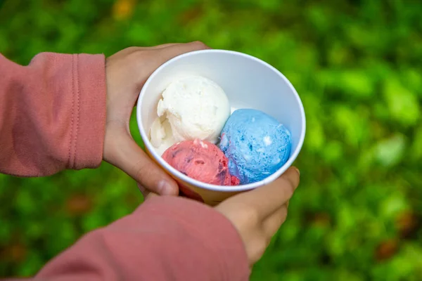 Three balls of ice cream in a jar are eaten in the park in summer. High quality photo