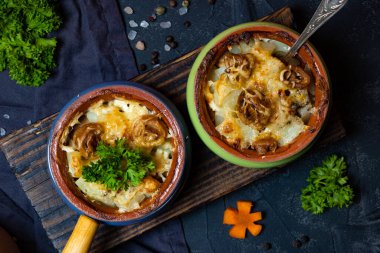  Julienne siyah arka planda porsiyonlu tencerelerde, üst tarafta, yakın planda. Yüksek kalite fotoğraf