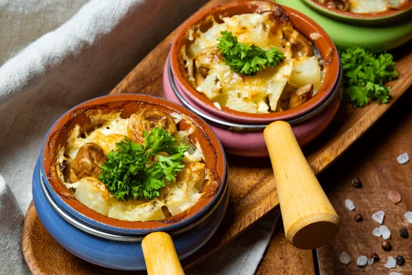 Julienne 'in porsiyonları ahşap bir masada yakın plan çekimde. Fransız mutfağı, mantarlı fırında patates. Yüksek kalite fotoğraf