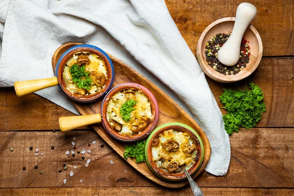 Three julienne pots on a wooden table, top view. French cuisine dish, baked potatoes with mushrooms. High quality photo — Stock Image Three Julienne Pots Wooden Table Top View French Cuisine Dish Stock Image