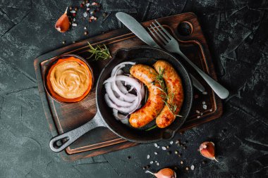  Siyah arka planda baharatları olan tavada ızgara sosis. Yüksek kalite fotoğraf