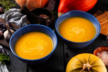  Siyah ahşap bir masada iki kase sıcak balkabağı çorbası yakın plan. Yüksek kalite fotoğraf