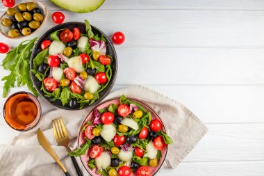  İki porsiyon taze sebze salatası - domates, marul, zeytin, roka ve zeytinyağı. Üst görünüm, boşluğu kopyala. Yüksek kalite fotoğraf