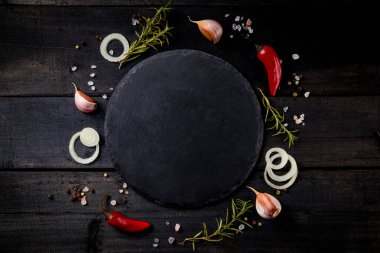  Ahşap arka planda yemek pişirme baharatlarıyla dolu boş bir levha. Üst görünüm, metin için boş alan. Yüksek kalite fotoğraf