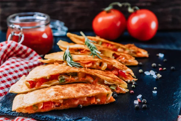 Meksika quesadilla 'sı siyah tabakta, yakın plan, yumuşak odaklı. Yüksek kalite fotoğraf