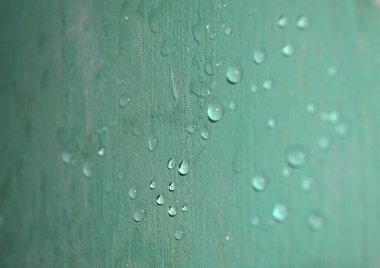 Duvardaki birçok yağmur damlası ışığın yansımasından dolayı parlak yeşil renktedir.