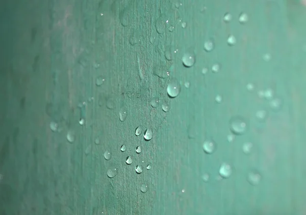 由于光的反射 墙上的许多雨滴都是闪亮的绿色 — 图库照片