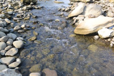 Öğleden sonra kayaların arasından akan su güneş ışığına maruz kalır.