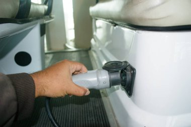 Elektrikli arabayı çalıştırmak için el fişi takılıyor. Ulaştırma Teknolojisi Konsepti
