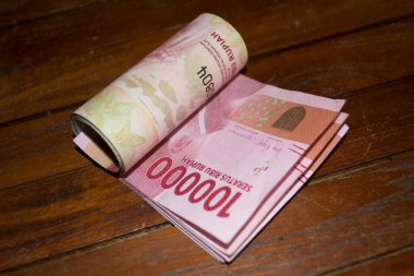 Endonezya rupia banknotları ahşap üzerine yuvarlanmış.