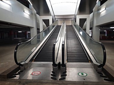 Binada boş yürüyen merdiven ve yerde bir tabela var.