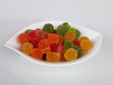 Beyaz arka planda beyaz bir kasede tatlı, karışık jöle şekerler, izole, üst manzara