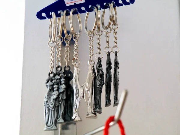 Key chains with catholic religious symbols in a pious articles shop, selective focus