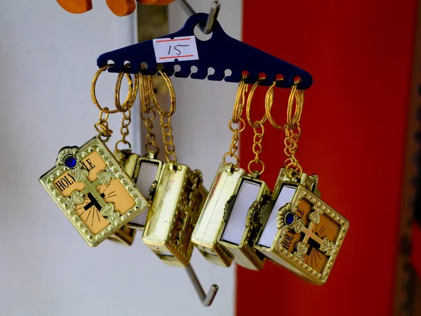 Key chains with catholic religious symbols in a pious articles shop, selective focus