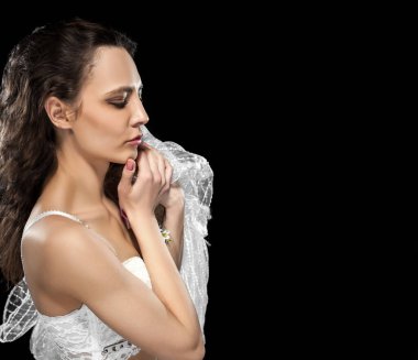 Siyah arka planda beyaz iç çamaşırlı zayıf kız. Tasarımcı el yapımı iç çamaşırı. Lüks iç çamaşırlarıyla poz veren bir model. Şaşırmış kız..