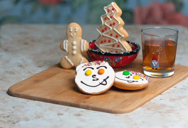 Holiday cookies and tea. Smiling cookies. Gingerbread man, tree and smiley. Gingerbread christmas party