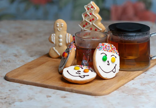 Holiday cookies and tea. Smiling cookies. Gingerbread man, tree and smiley. Gingerbread christmas party