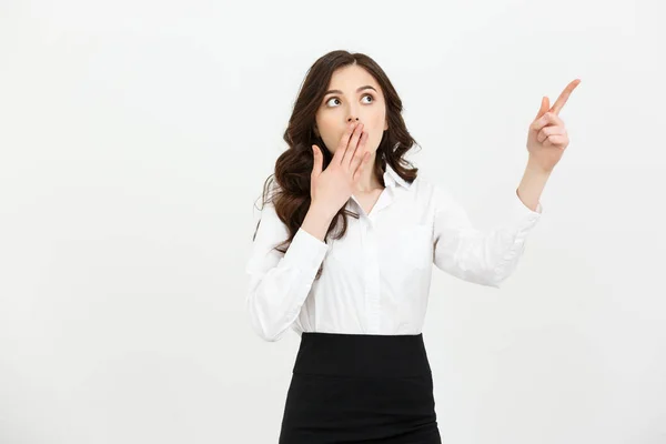 Business Concept: Portrait of surprised young businesswoman pointing finger away to copy space. Isolated on a white background. — Stock Photo, Image