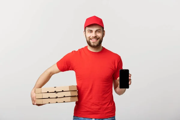 Homem de entrega de pizza segurando um celular e caixas de pizza sobre fundo branco. — Fotografia de Stock