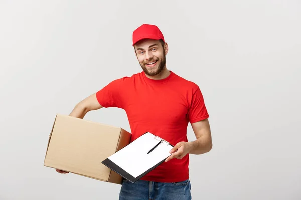Delivery Concept: Young handsome delivery man with paper boxes giving you a document to sign