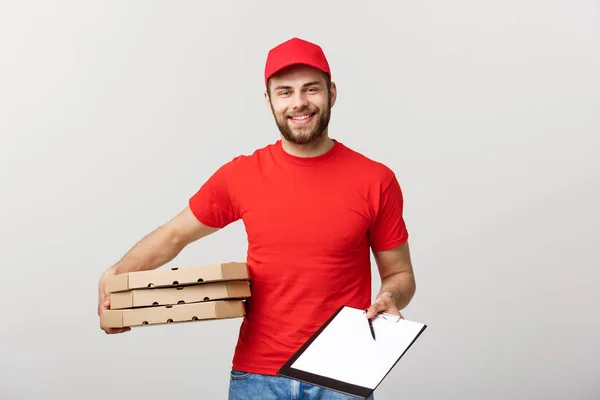 Concepto de entrega: Joven repartidor guapo con cajas de pizza que le da un documento para firmar —  Fotos de Stock