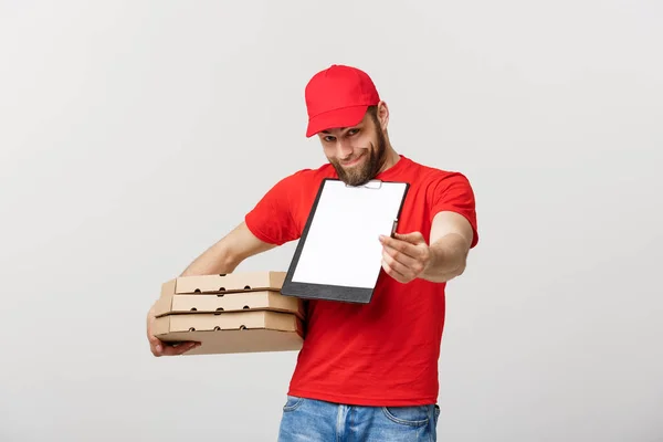 Delivery Concept: Young handsome delivery man with pizza boxes giving you a document to sign