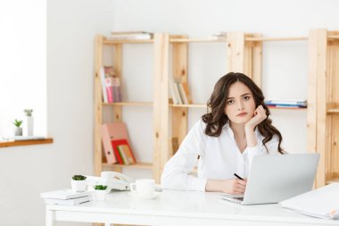 Güzel işkadını bilgisayar ve parlak office bazı iş belgelerde çalışırken kafasına elini tutarak yorgun