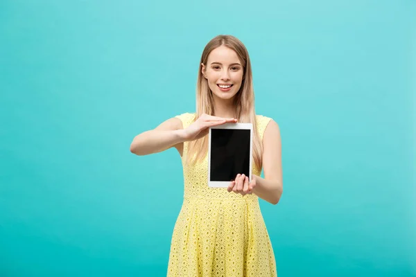 Mujer bastante sonriente mostrando la pantalla negra en blanco de la tableta digital. Aislado sobre fondo azul . — Foto de Stock