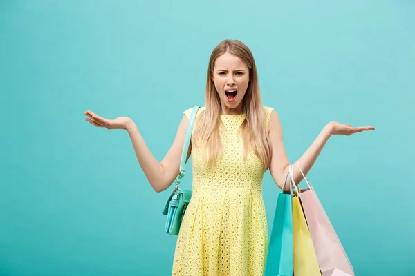 Nákupní a prodejní koncepce: krásná nešťastná mladá žena ve žlutých elegantních šatech s nákupní taškou. — Stock fotografie