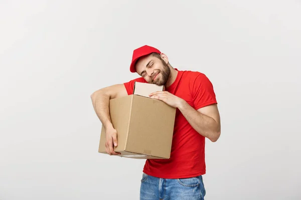 Ein junger Mann in roter Uniform umklammert leere Pappkartons auf weißem Hintergrund. Kopierfläche für Werbung — Stockfoto