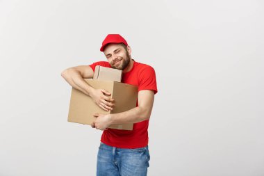 Beyaz arka plan üzerinde izole kırmızı üniforma huging boş karton kutular içinde teslim genç adam. Kopya alanı reklam için