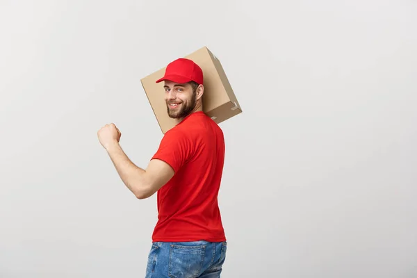 Concetto di consegna - vista posteriore del bell'uomo di consegna caucasico con pacchetto scatola. Isolato su sfondo grigio studio. Copia spazio . — Foto Stock