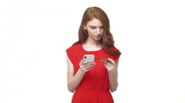 Yaklaşık bir karar Online ödeme kavram yavaş hareket için cep telefonu dijital e-ticaret üzerinde bir Online alışveriş satın alma yapmak için kredi kartını tutan genç kadın.