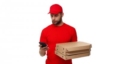 Pizza kutuları bir yığın tutarak ve sipariş cep telefonu kontrol kırmızı üniformalı servis elemanı. Beyaz arka plan üzerinde izole.