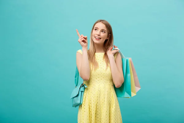 Hermosa joven en vestido amarillo apunta a algo con su dedo — Foto de Stock