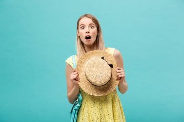 Şok ya da İyi Haber Konsepti: Uzun saçlı, uzun saçlı sarışın kız izole edilmiş mavi arka planda duruyor. Şaşkınlıkla ağzını açtı..