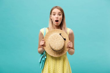 Şok ya da İyi Haber Konsepti: Uzun saçlı, uzun saçlı sarışın kız izole edilmiş mavi arka planda duruyor. Şaşkınlıkla ağzını açtı..