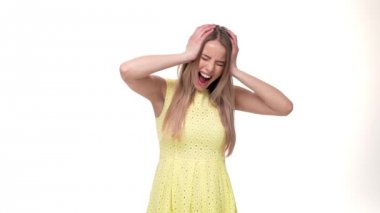 Kafasını eller yavaş gri arka plan üzerinde arasında tutan sinirli kadın