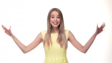 Sevimli kız gülümseyerek ve kameraya el gösterilmesini beyaz arka plan üzerinde ayakta