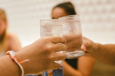 Boş zaman, tatil, yemek, insanlar ve yemek konsepti - arkadaşlar restoranda yemek yiyor ve içkileri tokuşturuyor