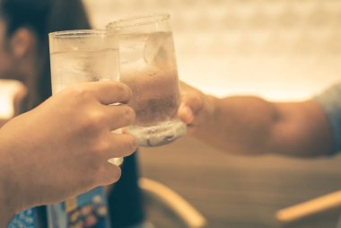 Boş zaman, tatil, yemek, insanlar ve yemek konsepti - arkadaşlar restoranda yemek yiyor ve içkileri tokuşturuyor