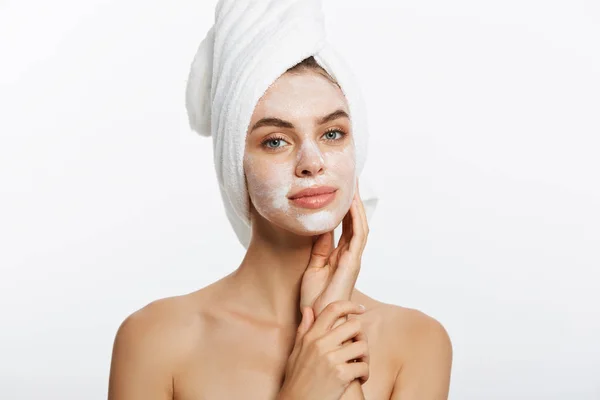 Primer plano de la hermosa joven aplicación de crema con toalla de baño en la cabeza —  Fotos de Stock